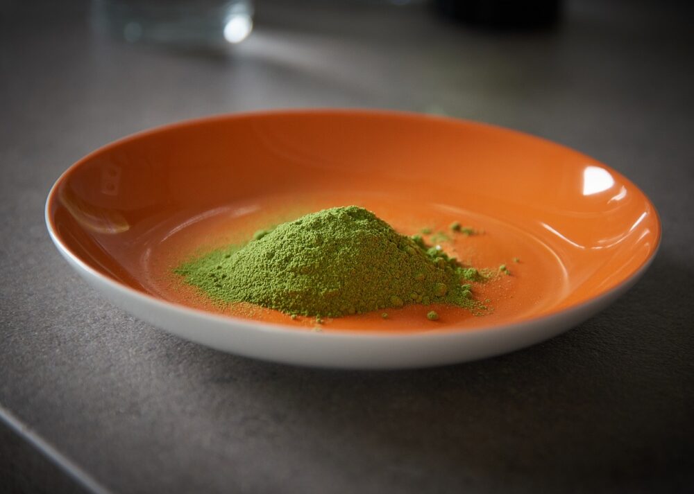 an orange bowl with a pile of moringa powder